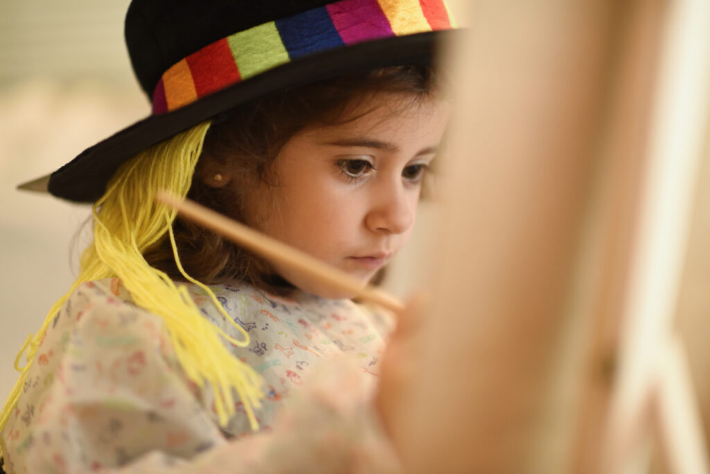 Little girl painting a picture at home to illustrate indoor activities for kids